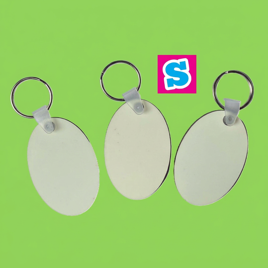 Three white oval MDF sublimation keyrings with silver split rings and Sublimania S logo on green background